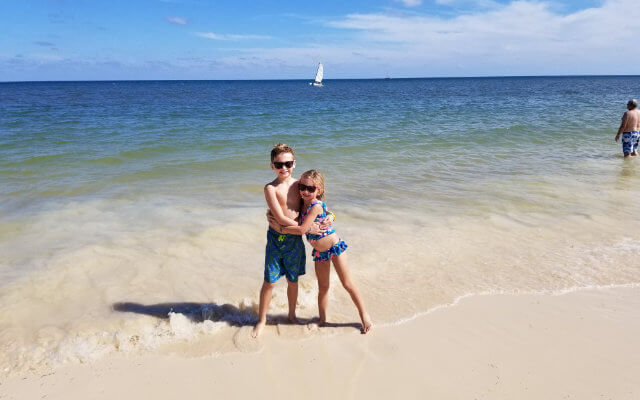 Two children hugging on the beach